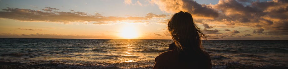 woman watching beach sunrise - lifestyle tips to lower cholesterol & stress