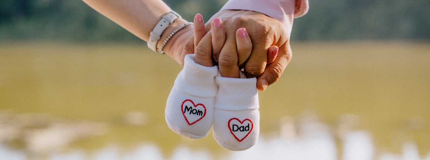 Small socks with the words mom and dad - becoming parents. 