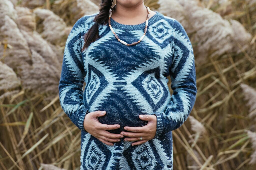 Pregnant woman in blue dress in field - fertility prep blog