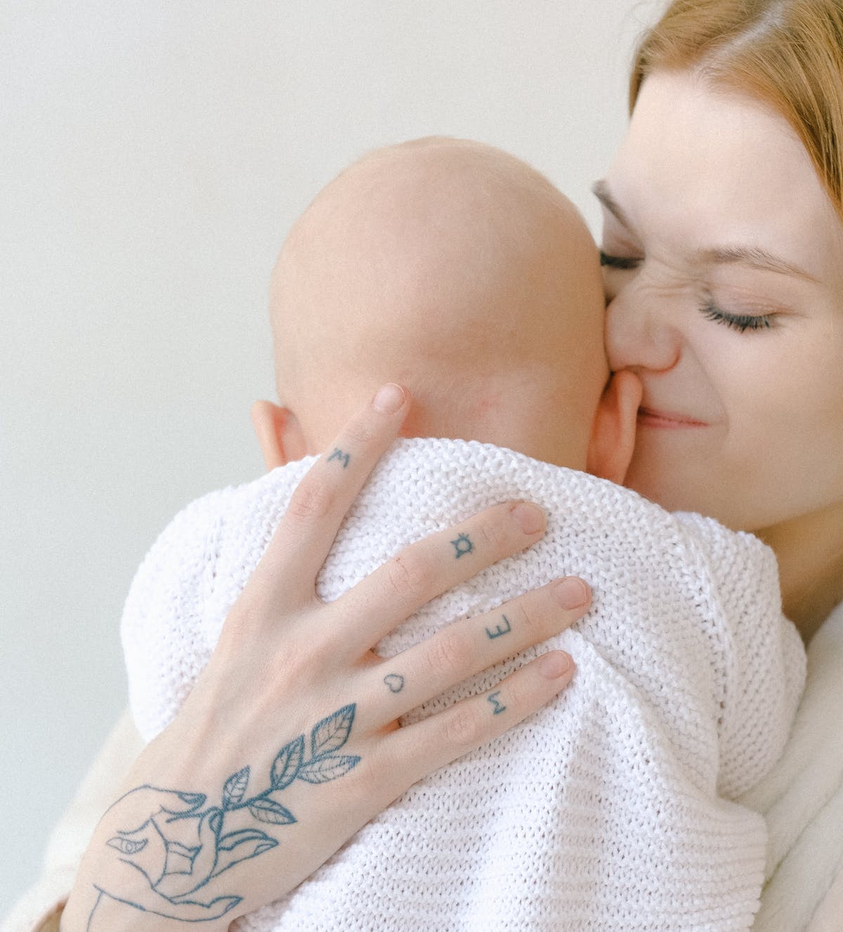 Mother with scrunchy face holding and loving on her baby